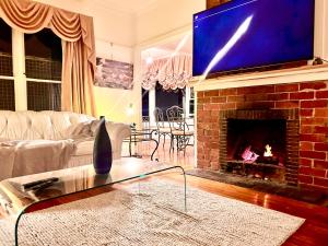 a living room with a fireplace with a tv above it at Stillwaters in Kalorama