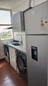 a kitchen with a refrigerator and a washing machine at Espacio 43 Terminal in La Plata +4 photos
