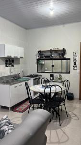 a kitchen with a table and chairs in a room at Apartamento Aconchego II in Alta Floresta