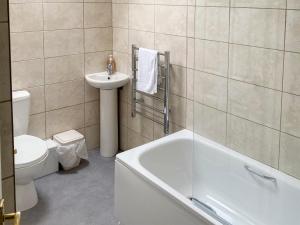 a bathroom with a tub and a sink and a toilet at Rosecraddoc Manor - Riverbank in Saint Cleer +8 photos