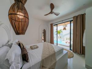 a bedroom with a bed and a view of a pool at Marram Villas 3 Prime Location in Paje
