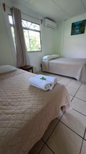a bedroom with two beds and a window at Cabinas Hidalgo in Ojochal