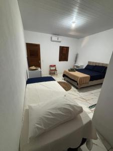 a bedroom with two beds and a couch at Cajuí da Vila Atins in Atins