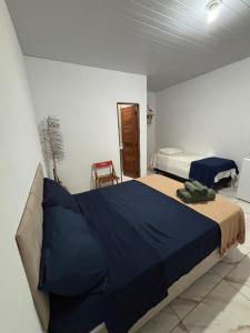 a bedroom with a bed with a blue comforter at Cajuí da Vila Atins in Atins