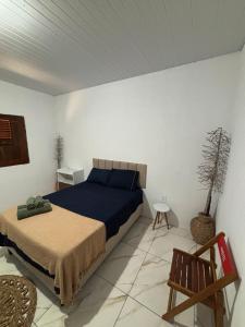 a bedroom with a bed and a chair in it at Cajuí da Vila Atins in Atins