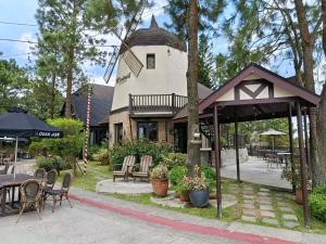 a patio with tables and chairs and a building at Alpine Villas Cozy Staycation in Ulot