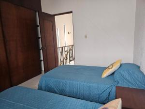 a bedroom with two beds and a surfboard on the pillow at Casa FLAMINGOS in Boca del Río