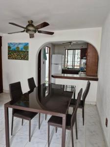 a dining room table with chairs and a ceiling fan at Casa FLAMINGOS in Boca del Río