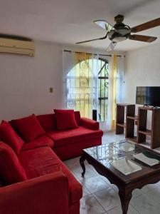 a living room with a red couch and a coffee table at Casa FLAMINGOS in Boca del Río