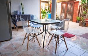 a glass table and four chairs in a room at POSADA CENTRO MAZUNTE RINCONCITo in Mazunte