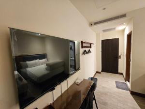 una camera da letto con una grande TV a schermo piatto sul muro di meet happiness a Hsia-pu-hsia