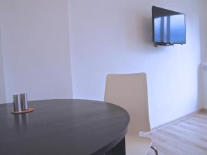 czarny stół z krzesłem i telewizor na ścianie w obiekcie Royal Way Snug - Old Town w Warszawie