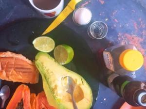 a table topped with a cut up avocado and lime slices at Hostel casa amarela in Rio das Ostras