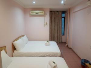 a hotel room with two beds and a window at BB Hotel in Gerik