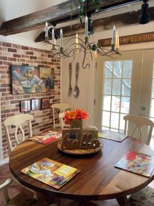 a dining room with a wooden table with flowers on it at The Zoo - This is it! in Saugatuck +10 photos