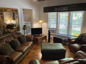 a living room with leather couches and a tv at The Zoo - This is it! in Saugatuck