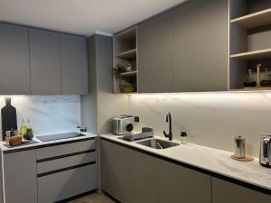 a kitchen with white cabinets and a sink at Las Condes Avenida in Santiago