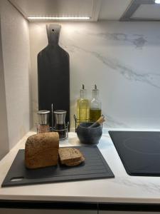 a table with a cutting board with bread and a laptop at Las Condes Avenida in Santiago