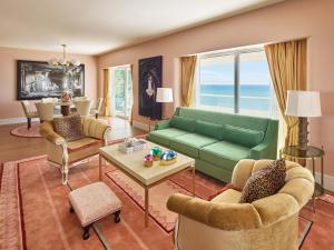 a living room with a green couch and chairs at Faena Miami Beach in Miami Beach