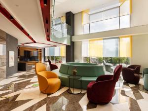 a lobby with a green couch and chairs at ibis Styles Istanbul Merter in Istanbul