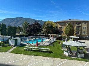 a large swimming pool with a building in the background at Empire Motel in Penticton