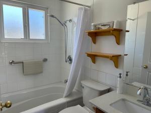 a bathroom with a tub and a toilet and a sink at Empire Motel in Penticton +27 photos