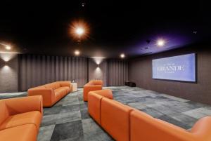 a room with orange chairs and a projection screen at Chada by Cadiz Properties - 2 Bedroom Apartment with Lakeview Pool, within CBD and Beside Commonwealth Park in Canberra +36 photos