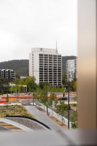 a view of a city with a large building at Chada by Cadiz Properties - 2 Bedroom Apartment with Lakeview Pool, within CBD and Beside Commonwealth Park in Canberra