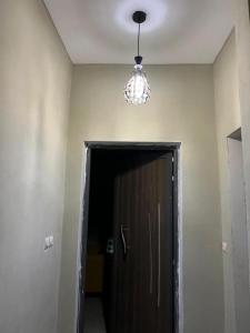 a room with a door and a chandelier on the ceiling at 1 lit en dortoir partagé - Résidences PRIMIS Thiès in Thies +2 photos