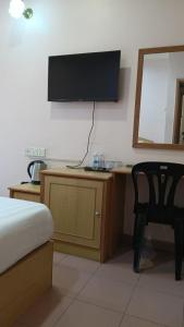 a bedroom with a bed and a desk with a television at BB Hotel in Gerik +16 photos