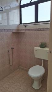 a bathroom with a toilet and a window at BB Hotel in Gerik