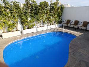 a large blue swimming pool on top of a building at Faraona Grand Hotel in Lima