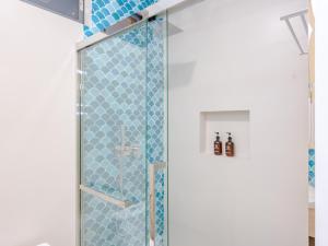 a bathroom with a shower with blue tiles at Biosphere Beach in Dharavandhoo +95 photos
