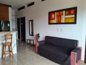 a living room with a couch and a kitchen at Cabañas Mar Caribe in Necoclí