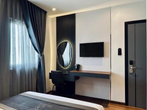 a hotel room with a desk and a mirror at LION 12 Hotel in Can Tho