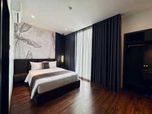 a bedroom with a bed and a large painting on the wall at LION 12 Hotel in Can Tho +38 photos