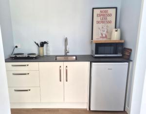 a kitchen with a sink and a microwave at Accomodation at Curio in Curio Bay