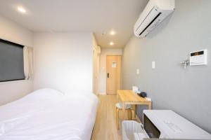 a hospital room with a bed and a desk at Kohoku Apartment in Tokyo