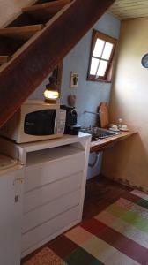 a small kitchen with a microwave and a sink at Cabana Jandaia in Teresópolis +51 photos