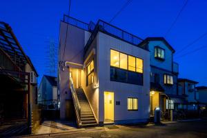 a house with its lights on in the night at Kohoku Apartment in Tokyo