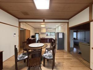 a dining room with a table and chairs and a kitchen at 蝶自来 in Yamaga