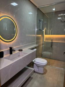 a bathroom with a sink and a toilet and a shower at Pousada Ebenezer in Garopaba