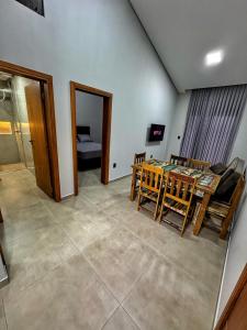 a living room with a table and chairs and a bedroom at Pousada Ebenezer in Garopaba