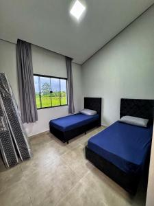 a bedroom with two beds and a window at Pousada Ebenezer in Garopaba