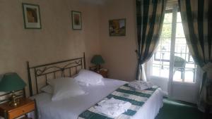 a bedroom with a bed with white sheets and a window at LOGIS - Hôtel & Restaurant Le Gonfalon in Germigny-lʼEvêque