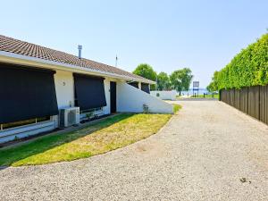 a house with a fence and a gravel driveway at No 3 Lakeside in Mulwala