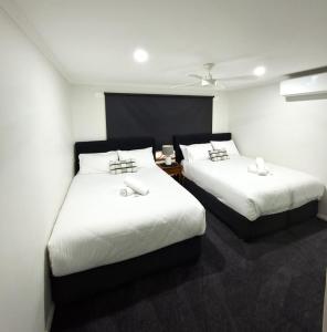 a bedroom with two beds with white sheets at No 3 Lakeside in Mulwala