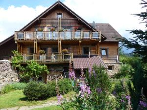 ein Haus mit einem Hund auf einem Balkon in der Unterkunft Stinglhof in Železná Ruda