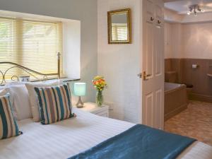 a bedroom with a bed and a bathroom with a tub at Rosecraddoc Manor - Natalie Jane in Saint Cleer