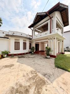 a large white house with a large driveway at Bon Voyaage Villa in Trincomalee